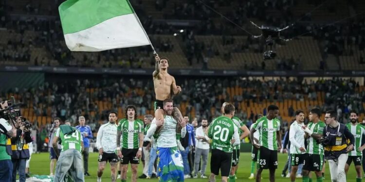 Afición del Real Betis con una bandera verdiblanca en el estadio.
